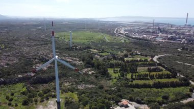 Sardunya 'nın güneyindeki bir ovadaki rüzgâr tarlasında güzel mavi bir gökyüzünde rüzgar türbinleri. Yenilenebilir enerji konsepti, yeşil enerji üretimi, Portoscuso Güney Sardinya