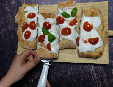 Domates, mozzarella ve fesleğenli margherita aromalı Roma pinsası.