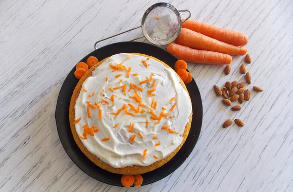carrot cake or camilla cake with fresh cato and almonds on black plate and white background