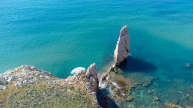 Kartal Yuvası, Sardunya 'nın batı kıyısının karakteristik yığınlarından biridir. Arka planda ise güzel kristal deniz Buggerru.
