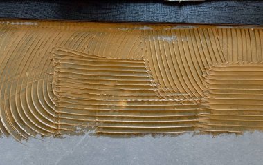 İşçiler Listone Giordan 'ı sermek için parke yapıştırıcısı sürerler.