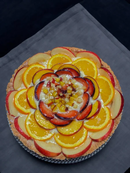 Piece of peach tart with fresh fruits on wooden table, top view