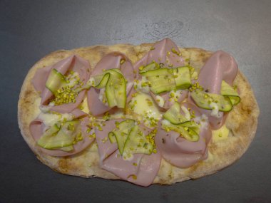 Roma pinsa 'sı, klasik İtalyan pizzasının bir çeşidi. Mortadella, stracciatella ve kuzu marulu ve şam fıstıklı.