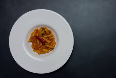 Klasik İtalyan makarnası penne arrabiata ve biberli fesleğen. Kızgın biber soslu makarna..