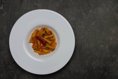 Klasik İtalyan makarnası penne arrabiata ve biberli fesleğen. Kızgın biber soslu makarna..