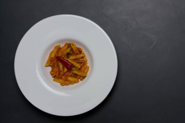 Klasik İtalyan makarnası penne arrabiata ve biberli fesleğen. Kızgın biber soslu makarna..