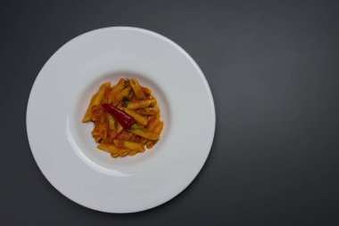 Klasik İtalyan makarnası penne arrabiata ve biberli fesleğen. Kızgın biber soslu makarna..