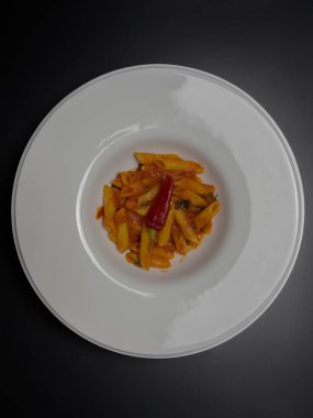 Klasik İtalyan makarnası penne arrabiata ve biberli fesleğen. Kızgın biber soslu makarna..