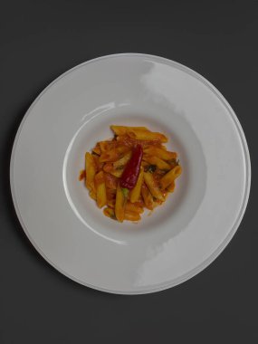 Klasik İtalyan makarnası penne arrabiata ve biberli fesleğen. Kızgın biber soslu makarna..