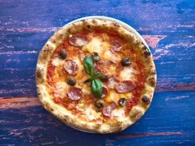 Kenarlı Napoli pizzası, baharatlı biber domates ve koyu arkaplanda mozzarella. Mozzarella 'lı pizza, domates sosu, acı biber.