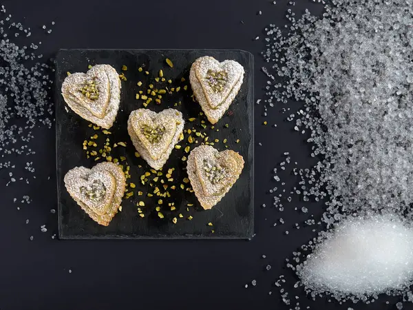 Valentine's Day sweets in the shape of a heart with pistachio cream and icing suga