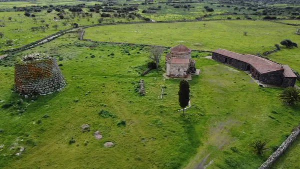 stock image Nuraghe Santa Sabina in Silanus in central Sardinia with the church of Santa Serbana next to i