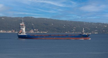 Silah yüklemek için limana girmeyi bekleyen bir ticaret gemisi.