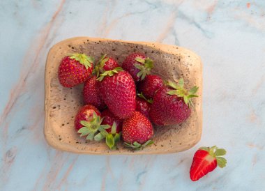 Mantar kapta olgun çilekler ve beyaz mermer arka plan