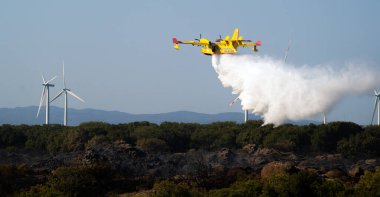 Carbonia, İtalya, 8 Ağustos 2024: Bir Kanadalı, itfaiyecilerin amfibik su bombacısı yangını söndürmeye çalışıyor