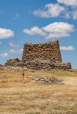 İtalya, Sardunya 'daki Nuraghe Piscu' nun görkemli harabeleri, canlı mavi gökyüzüne karşı dimdik ayakta duruyor, antik megalitik mimariyi gözler önüne seriyor.