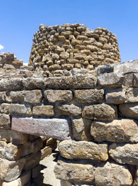 İtalya, Sardunya 'daki Nuraghe Piscu' nun görkemli harabeleri, canlı mavi gökyüzüne karşı dimdik ayakta duruyor, antik megalitik mimariyi gözler önüne seriyor.