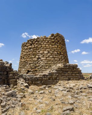 İtalya, Sardunya 'daki Nuraghe Piscu' nun görkemli harabeleri, canlı mavi gökyüzüne karşı dimdik ayakta duruyor, antik megalitik mimariyi gözler önüne seriyor.