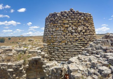 İtalya, Sardunya 'daki Nuraghe Piscu' nun görkemli harabeleri, canlı mavi gökyüzüne karşı dimdik ayakta duruyor, antik megalitik mimariyi gözler önüne seriyor.