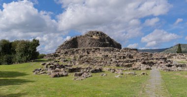 Ancient megalithic edifice of nuragic civilization, dating back to the bronze age, stands majestically against a vibrant sky clipart