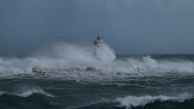 Kasırga sırasında Mangiabarche deniz fenerine çarpan güçlü dalgalar, dayanıklılığı ve doğanın gücünü simgeliyor.