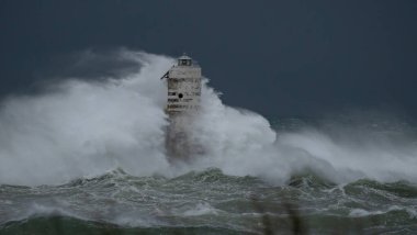 Kasırga sırasında Mangiabarche deniz fenerine çarpan güçlü dalgalar, dayanıklılığı ve doğanın gücünü simgeliyor.