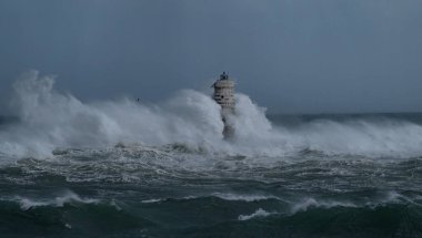 Kasırga sırasında Mangiabarche deniz fenerine çarpan güçlü dalgalar, dayanıklılığı ve doğanın gücünü simgeliyor.