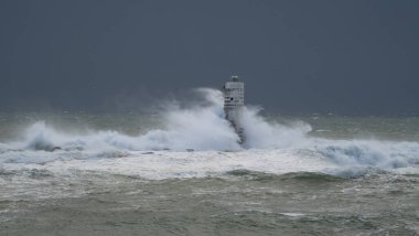 Kasırga sırasında Mangiabarche deniz fenerine çarpan güçlü dalgalar, dayanıklılığı ve doğanın gücünü simgeliyor.
