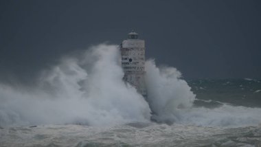Kasırga sırasında Mangiabarche deniz fenerine çarpan güçlü dalgalar, dayanıklılığı ve doğanın gücünü simgeliyor.