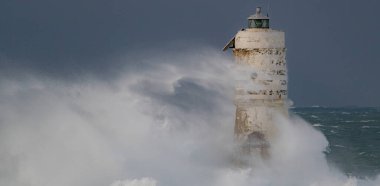 Kasırga sırasında Mangiabarche deniz fenerine çarpan güçlü dalgalar, dayanıklılığı ve doğanın gücünü simgeliyor.