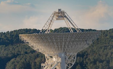 Large radio telescope exploring the universe surrounded by nature under a cloudy sky clipart