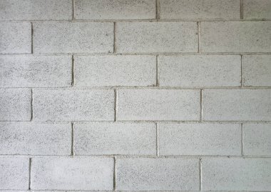 Beyaz boyalı beton blok duvar temiz ve desenli bir zemin sağlıyor