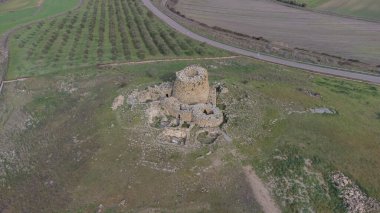 Majestic ruins of nuraghe Piscu in sardinia, italy, stand tall against a vibrant blue sky clipart