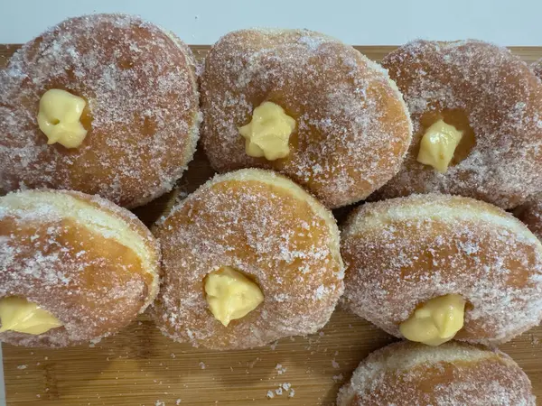 Bomboloni, İtalyan çörekleri kremalı kremayla dolu, tahtadan bir yüzeye şeker serpiştirilmiş.