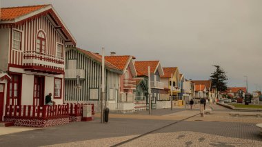 Aveiro, Portekiz- 15 Temmuz 2025 - Kosta Nova, Portekiz 'de renkli çizgili evlere hayran olan turist