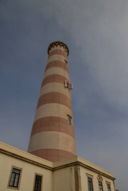 Farol do Barra aveiro lighthouse in Aveiro district, standing tall on a cloudy day clipart