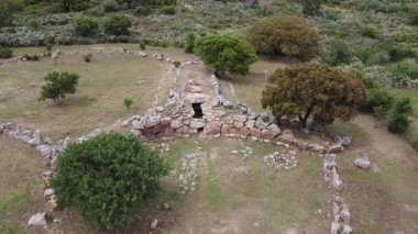Sardunya 'da granit taşlar, yarı dairesel eksra ve panoramik kırsal çevreyle Nuragic mezarlığı.