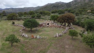 Sardunya 'da granit taşlar, yarı dairesel eksra ve panoramik kırsal çevreyle Nuragic mezarlığı.