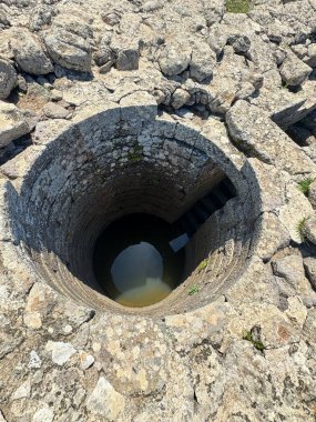 Serri 'deki Santa Vittoria' nın Nuragic Tapınağı 'nın bir parçası olan su dolu antik taş kaplı kutsal kuyu.