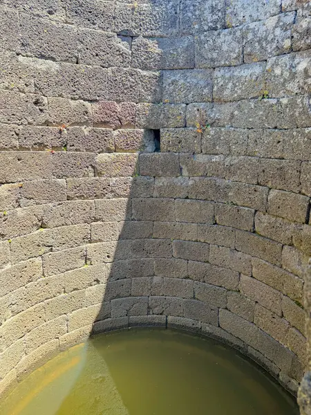 Serri 'deki Santa Vittoria' nın Nuragic Tapınağı 'nın bir parçası olan su dolu antik taş kaplı kutsal kuyu.