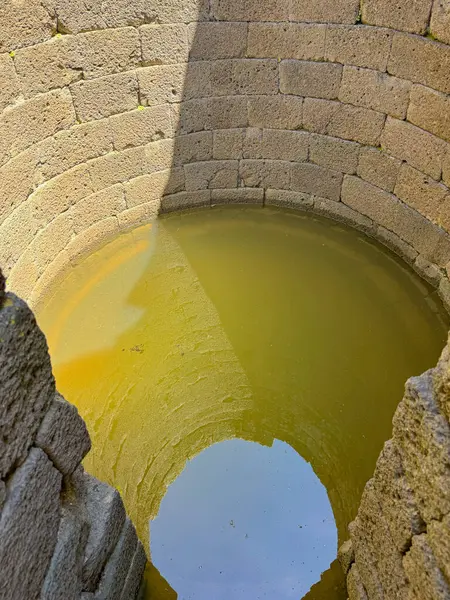 Serri 'deki Santa Vittoria' nın Nuragic Tapınağı 'nın bir parçası olan su dolu antik taş kaplı kutsal kuyu.
