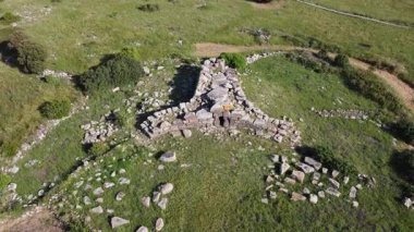 Siddi, Sardinya 'daki tarih öncesi bir dev mezarın insansız hava aracı görüntüsü. Çimenli bir arazide Nuragic megalitik mimarisi.