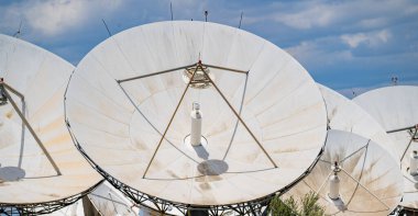 Bir yer telekomünikasyon istasyonundaki çoklu uydu antenlerinin yakın görüntüsü. 