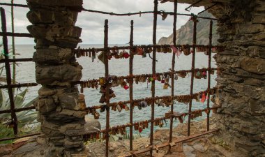 Monterosso, Liguria 'da denize bakan asma kilitlerle kaplı paslı demir parmaklıklar.