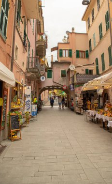 Renkli şemsiyeli, tarihi villalı ve Cinque Terre 'deki yeşil tepeli Monterosso sahili manzarası.