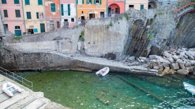 Resimli Riomaggiore limanında parlak renkli evler ve tekneler, Cinque Terre, İtalya