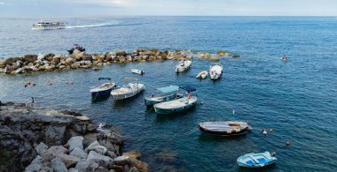 Resimli Riomaggiore limanında parlak renkli evler ve tekneler, Cinque Terre, İtalya