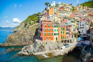 Resimli Riomaggiore limanında parlak renkli evler ve tekneler, Cinque Terre, İtalya