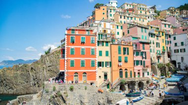 Resimli Riomaggiore limanında parlak renkli evler ve tekneler, Cinque Terre, İtalya