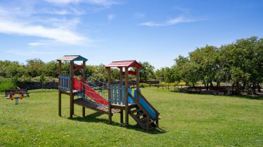 Nuraghe Su Mulinu yakınlarındaki yeşil park alanında renkli ahşap oyun alanı 